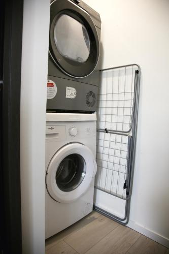 a bathroom with a washing machine and a mirror at La Loge en Or - Parking public - Triplex - Proche centre et autoroute in Lens