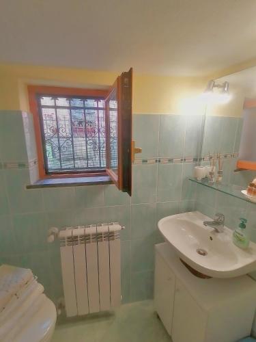 a bathroom with a sink and a toilet and a window at Da Greta - Biassa in La Spezia