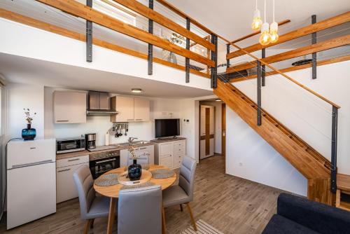 a kitchen and dining room with a table and a staircase at Villa Aurelia in Zadar