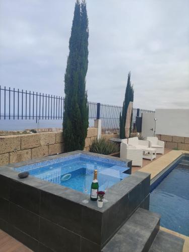 a bottle of wine sitting next to a swimming pool at VILLA Atlantico Views in Candelaria