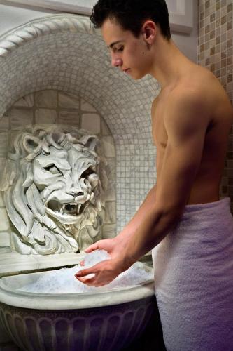 a man standing in front of a bath tub at Hotel Sassella in Grosio