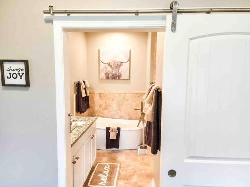 a bathroom with a white tub and a sink at Canyon Lake Oasis! 3 MIN to Boat Ramp Pet Friendly in Canyon Lake
