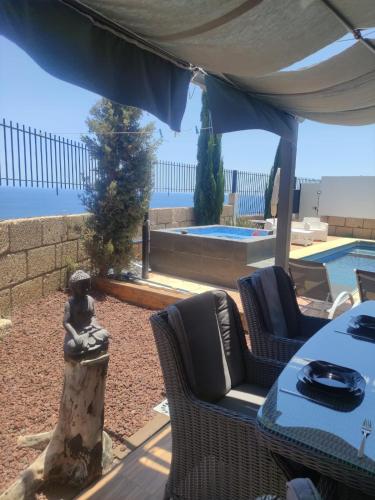 a patio with a table and chairs and a pool at VILLA Atlantico Views in Candelaria