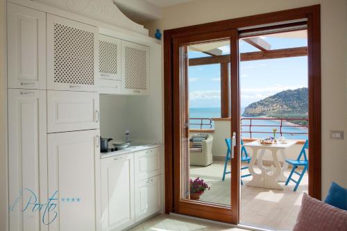 a kitchen with a door leading to a balcony at Hotel Residence Il Porto in Mattinata