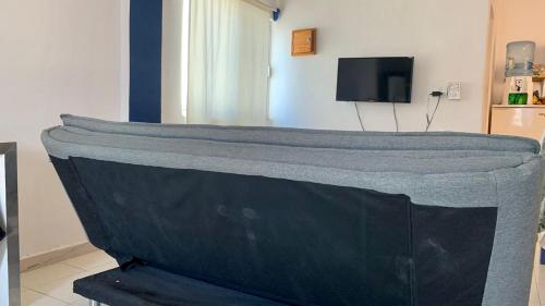 un sofá en una sala de estar con TV en Apartamento en Playa del Carmen, en Playa del Carmen