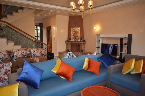 ein Wohnzimmer mit einem blauen Sofa und bunten Kissen in der Unterkunft Villa Marrakech in Marrakesch