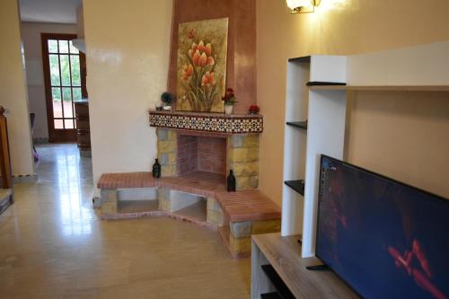 ein Wohnzimmer mit einem Kamin und einem TV in der Unterkunft Villa Marrakech in Marrakesch