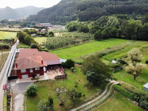 a house in the middle of a field next to a mountain at hotel el candano in Pravia