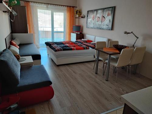a living room with a bed and a table at Slnečné apartmány in Podhájska