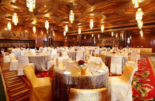 a banquet hall with white tables and chairs and chandeliers at The Ashok, New Delhi in New Delhi