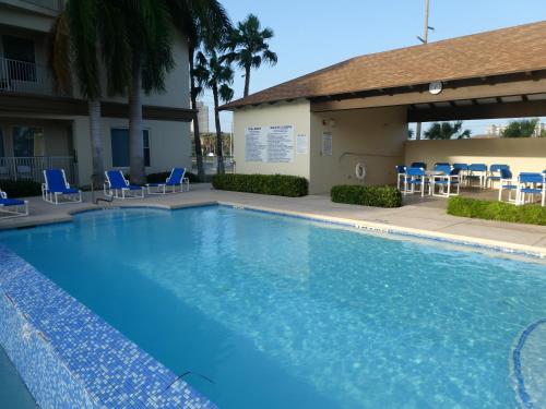 a large swimming pool with blue chairs and a building at Fishermans Landing on The Bay- Las Marinas in South Padre Island