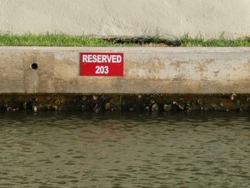 a red sign on the side of a body of water at Fishermans Landing on The Bay- Las Marinas in South Padre Island