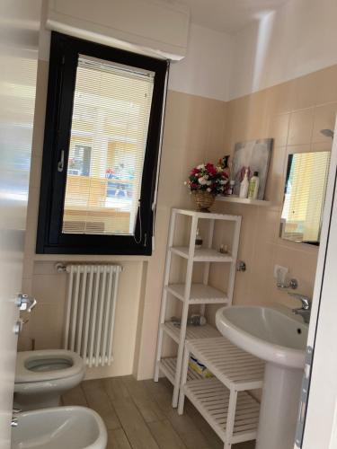 a bathroom with a sink and a toilet and a window at Casa Lisa in Lenno