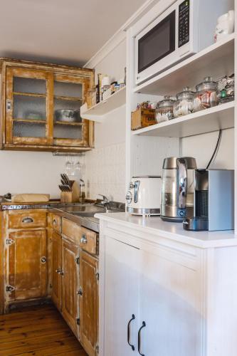 a kitchen with wooden cabinets and a microwave at Aldgate Valley Bed and Breakfast in Aldgate