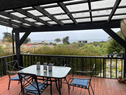 un patio con mesa y sillas en una terraza en Amplia casa frente al mar, camino a Punta de Lobos en Pichilemu