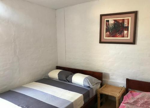 a bedroom with two beds and a picture on the wall at Casa Máncora Guesthouse in Máncora