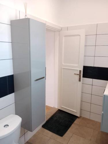 a bathroom with a toilet and a glass shower door at Comme chez soi 2 in Tchimbanmba