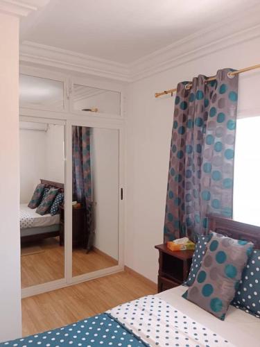 a room with a bed and a mirror and a bedroom at Comme chez soi 2 in Tchimbanmba
