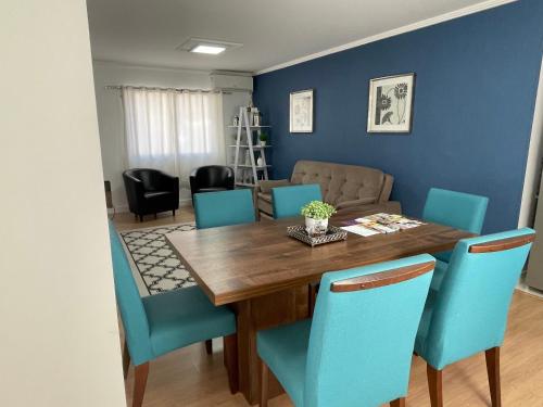 une salle à manger avec une table en bois et des chaises bleues dans l'établissement Melhor Casa para locação em Pomerode, à Pomerode