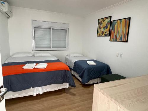 Cette chambre comprend 2 lits et une fenêtre. dans l'établissement Melhor Casa para locação em Pomerode, à Pomerode