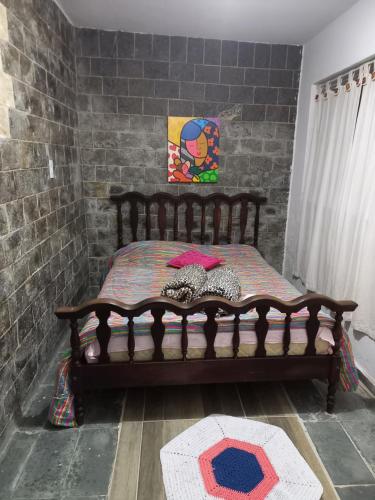 a wooden bed in a room with a brick wall at Apartamento para casal em São Lourenço in São Lourenço