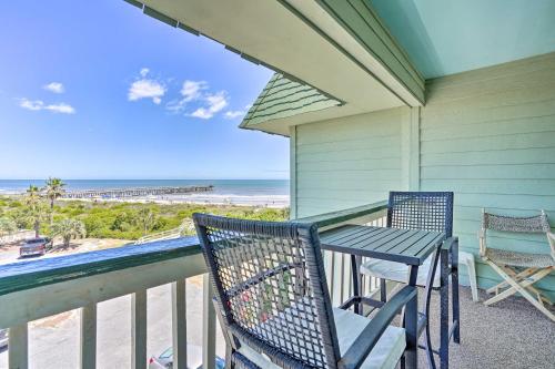 a porch with two chairs and a table and the beach at Beachfront Isle of Palms Condo with Balcony and Pool! in Isle of Palms