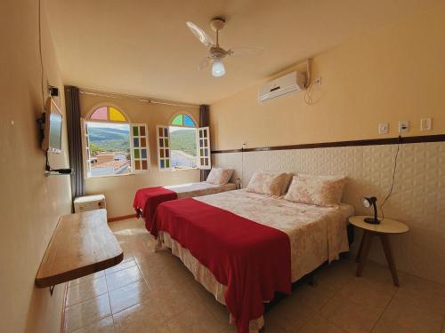 a bedroom with two beds and a window at Pousada da Villa in Lençóis