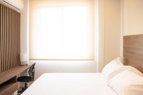 a bedroom with a white bed and a window at Edificio Casa Tabor in Barranquilla