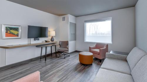 a living room with a couch and a desk and a tv at Holiday Inn & Suites Bellingham by IHG in Bellingham