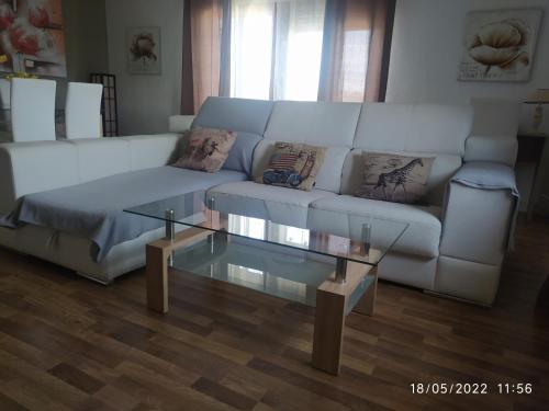 a living room with a white couch and a glass table at Piso Navas in Navas de San Antonio