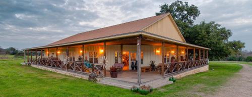 a large house with a large porch with windows at Round Top Hotel in Round Top
