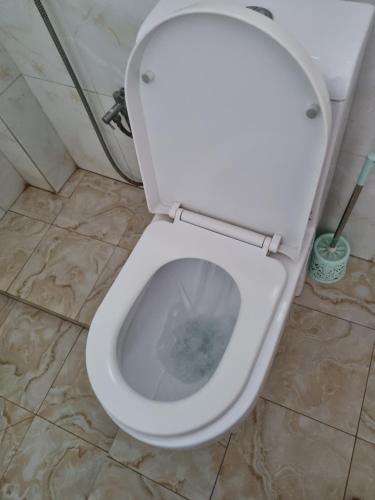 a bathroom with a toilet with the seat up at Mini Studio au rez de chaussée in Ouakam