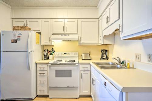 a kitchen with white appliances and white cabinets at Isle of Palms Condo with Pool Access Walk to Beach! in Isle of Palms