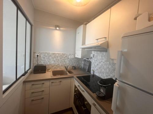 une petite cuisine avec un évier et un réfrigérateur dans l'établissement Studio 2* avec balcon face à la mer, ascenseur, proche plage et commerces, 2 pers. - FR-1-197-387, à Les Sables-dʼOlonne