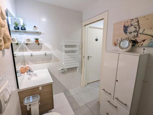 une salle de bain blanche avec un lavabo et un miroir dans l'établissement Arcachon centre ville - Charmant T2 avec balcon, parking sécurisé, proche gare, commerces et plage - FR-1-420-90, à Arcachon