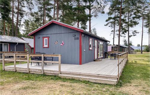 un pequeño cobertizo con una terraza de madera en un campo en 3 Bedroom Cozy Home In Löttorp, en Löttorp
