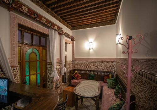 een woonkamer met een tafel en een glas-in-loodraam bij Riad Dar Barae in Fès al Bali