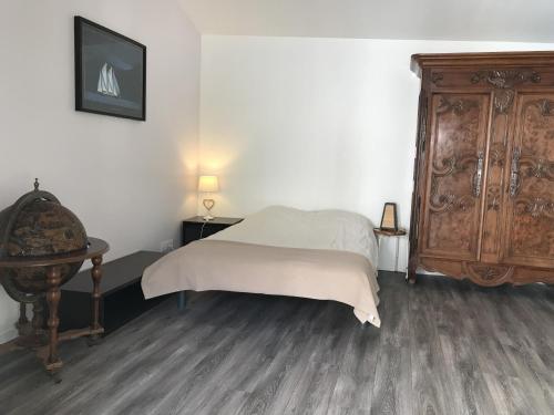 une chambre avec un lit et une commode en bois dans l'établissement Maison familiale entre plage et pins, 13km de sable fin, proche nature, 5 ch, confort équipé, animaux ok - FR-1-22-304, à La Tranche-sur-Mer