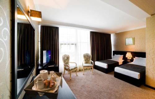 a hotel room with two beds and a television at Kalasi Hotel in Tbilisi City