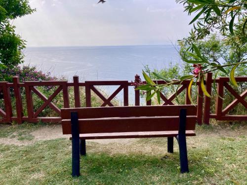 a wooden bench sitting in front of a fence at Karden Otel in Antalya
