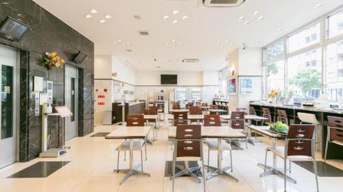 a cafeteria with tables and chairs in a building at Toyoko Inn Shin-Osaka Chuo-guchi Shinkan in Osaka