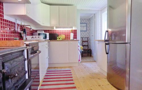 a kitchen with white cabinets and a stainless steel refrigerator at Holiday Home Nyttorp Högsby in Hultsnäs