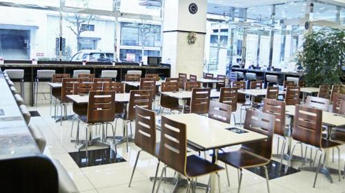 uma cafetaria com mesas e cadeiras num edifício em Toyoko Inn Shin-osaka Higashi-mikuni Ekimae em Osaka