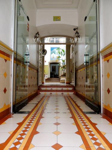 a hallway of a building with a tile floor at Hotel La Orquidea in Cuenca