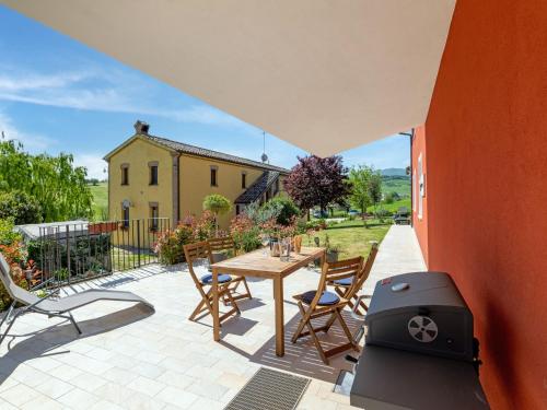 a patio with a barbecue and a table and chairs at Rural Pool Escape in Matelica in Matelica