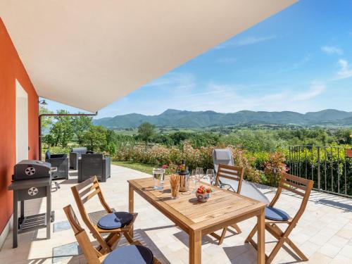 a patio with a wooden table and chairs and a grill at Rural Pool Escape in Matelica in Matelica