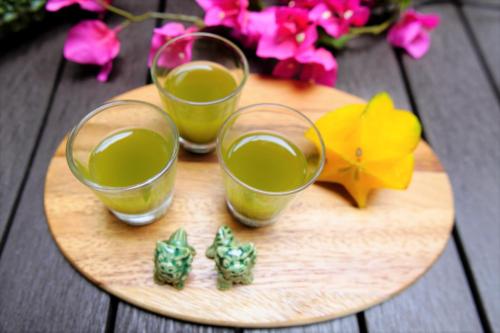 two glasses of juice on a wooden tray with flowers at Hotel Palm Royal Resort Kokusai Street in Naha