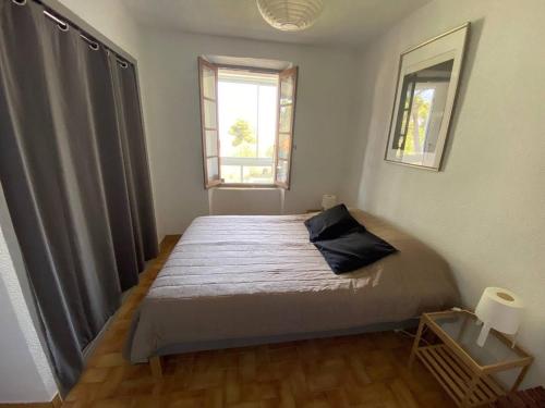 une chambre avec un lit dans une pièce avec une fenêtre dans l'établissement Appartement pour 4 pers, proche plage, parking, terrasse, commerces à proximité - FR-1-81-559, à La Franqui-Plage