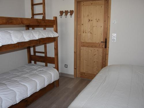 sypialnia z 2 łóżkami piętrowymi i drzwiami w obiekcie Appartement familial avec parking et proche des pistes - FR-1-464-201 w mieście Pralognan-la-Vanoise