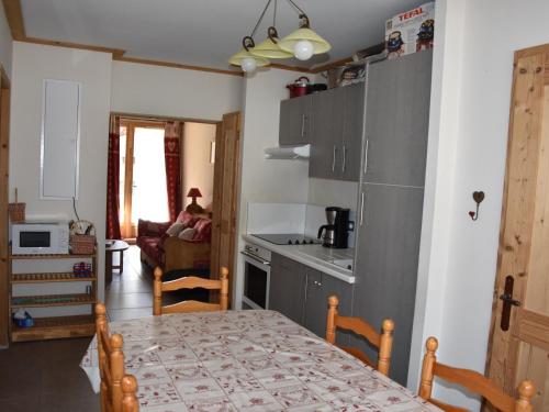 une cuisine et une salle à manger avec une table et une cuisine gmaxwell gmaxwell dans l'établissement Appartement familial avec parking et proche des pistes - FR-1-464-201, à Pralognan-la-Vanoise
